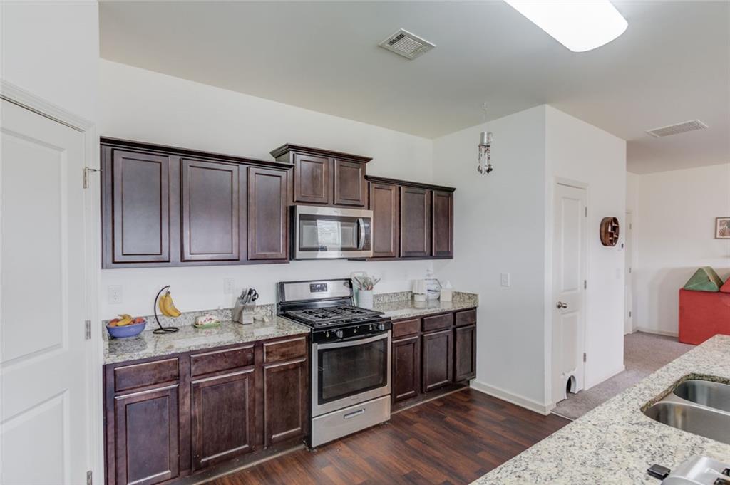 331 Merigold Way Pendergrass, GA 30567 - Photo 13 of 39 a kitchen with stainless steel appliances granite countertop a sink stove and cabinets