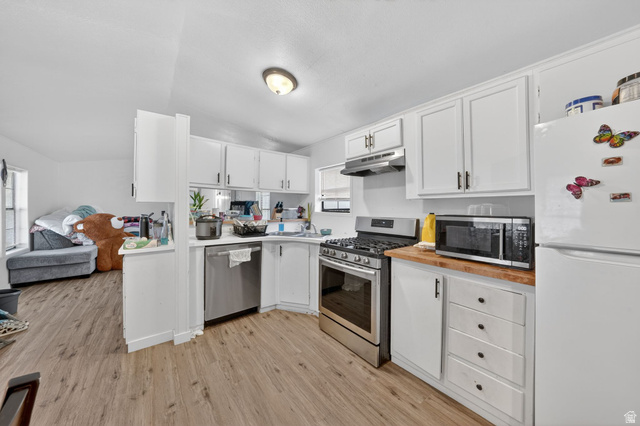262 Hidden View Drive, Unit 94 Sandy, UT 84070 - Photo 7 of 18 Kitchen featuring stainless steel appliances, white cabinetry, wood counters, light wood-style floors, and lofted ceiling
