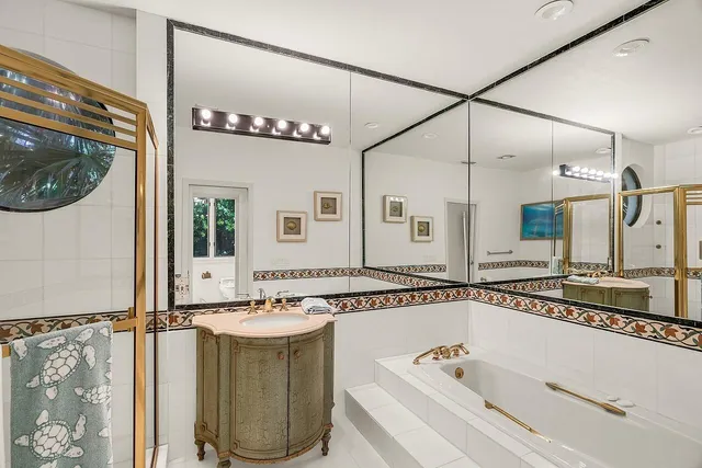 a bathroom with a tub a sink and a mirror