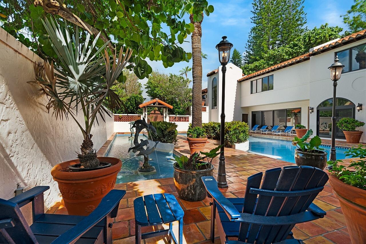 1 Ocean Lane Manalapan, FL 33462 - Photo 15 of 95 a view of a patio with table and chairs potted plants and a palm tree