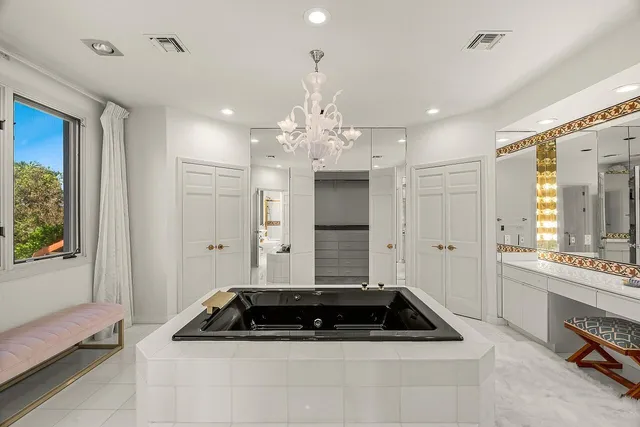 a room with kitchen island a sink and a refrigerator