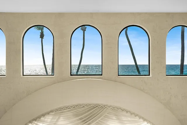 a bedroom with a bed and a large window with balcony view