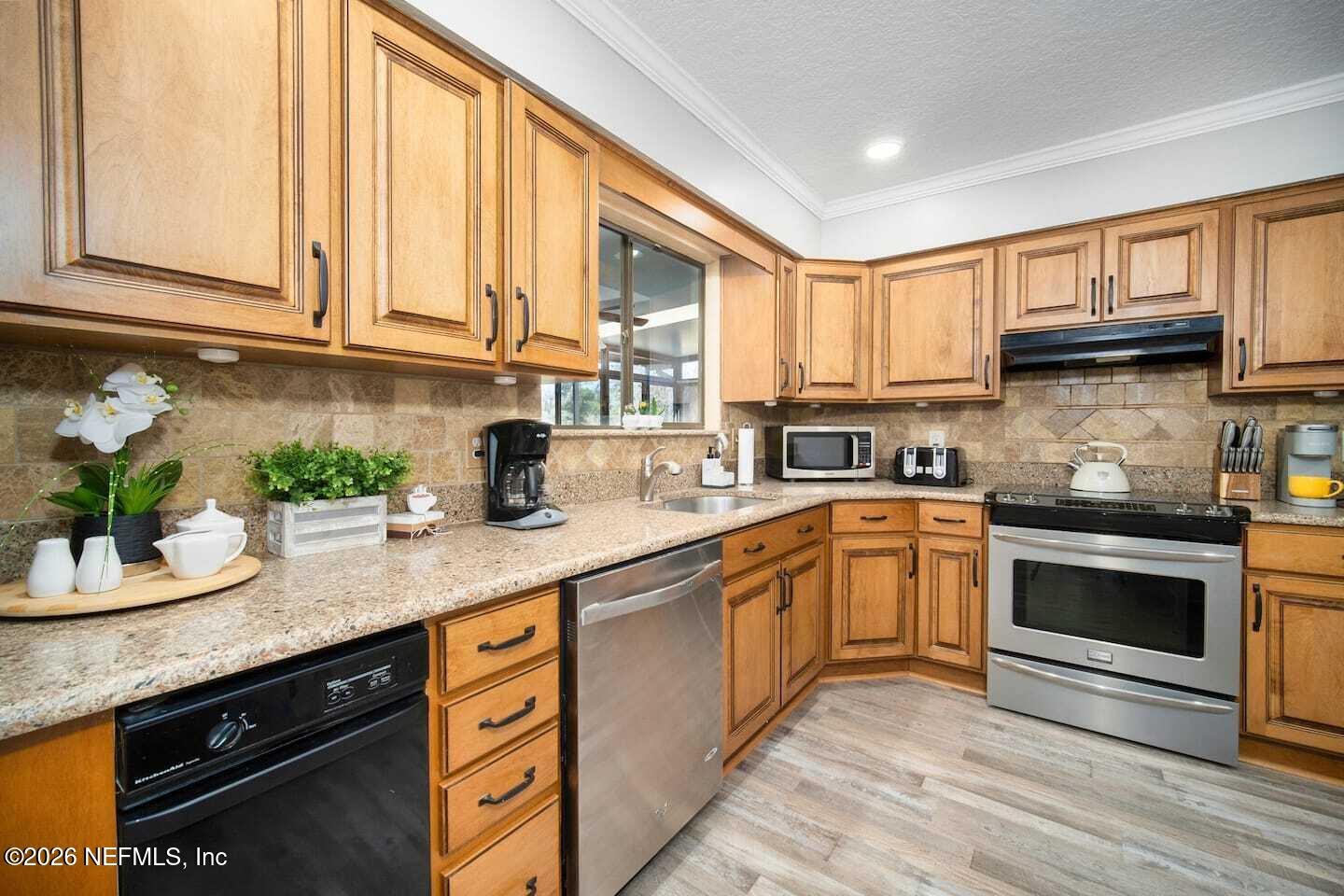 11613 Lake Ride Drive Jacksonville, FL 32223 - Photo 21 of 42 a kitchen with stainless steel appliances granite countertop a sink a stove cabinets and a window