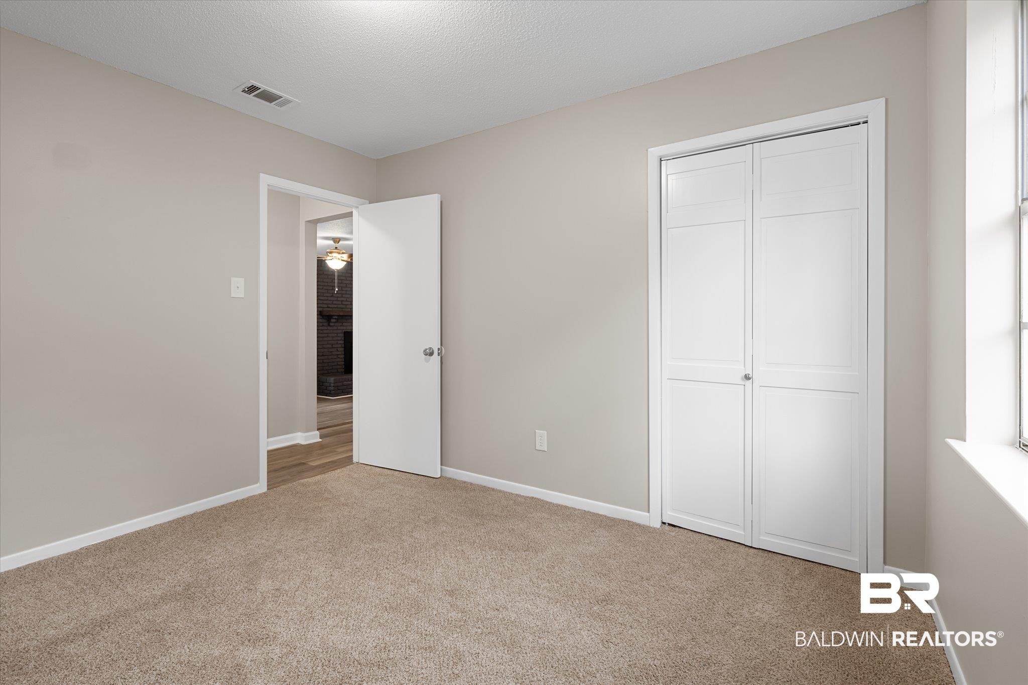 5015 Golfway Drive Eight Mile, AL 36613 - Photo 19 of 31 Unfurnished bedroom with a closet, light carpet, and a textured ceiling