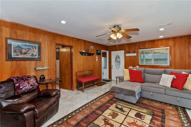 a living room with furniture a flat screen tv and a floor to ceiling window