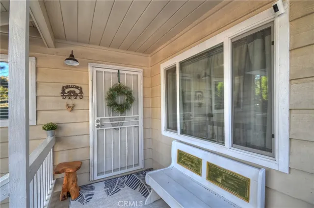 a view of a porch with wooden floor and furniture