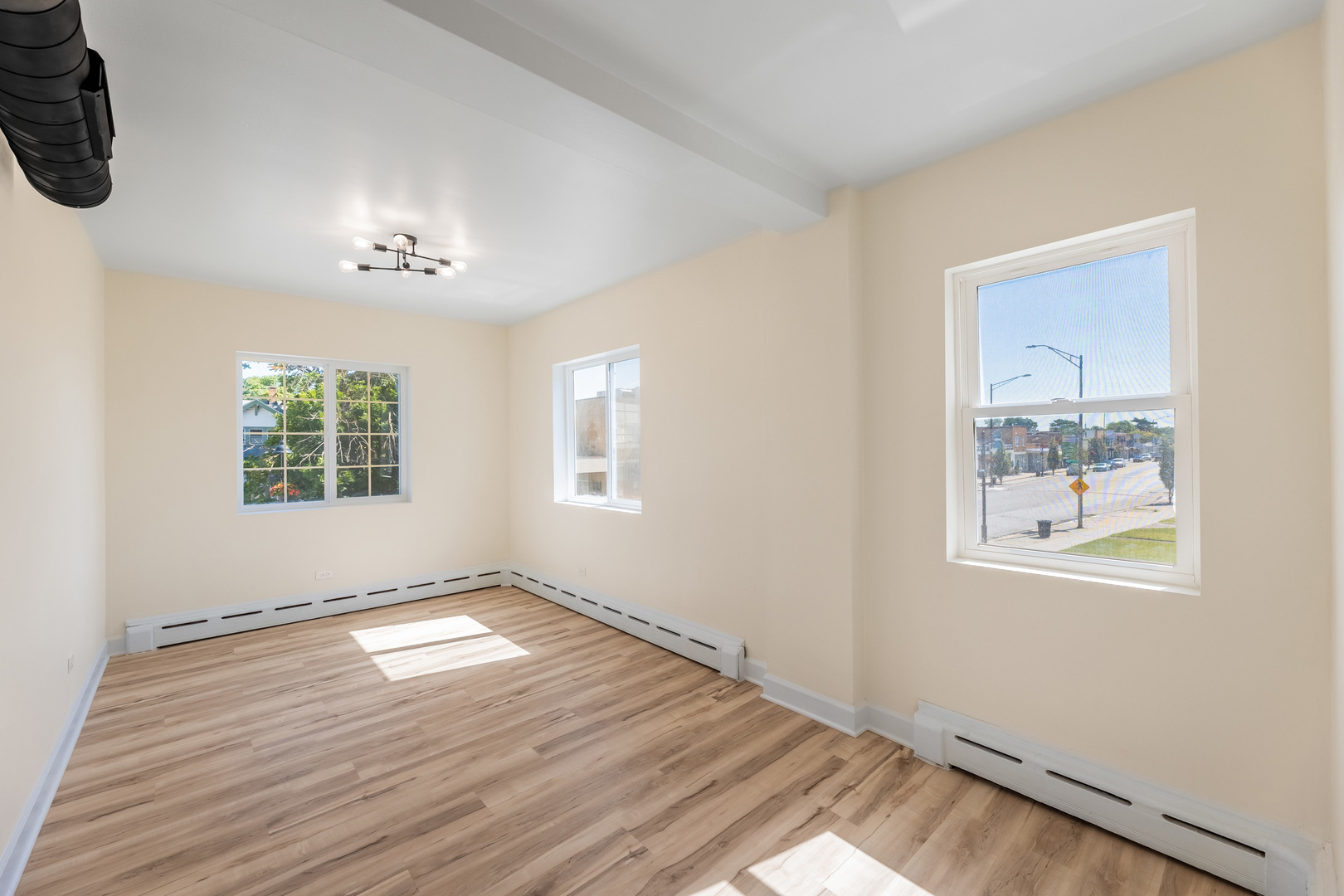 3243 Ridge Road, Unit 2 Lansing, IL 60438 - Photo 10 of 13 a view of an empty room with a window and wooden floor