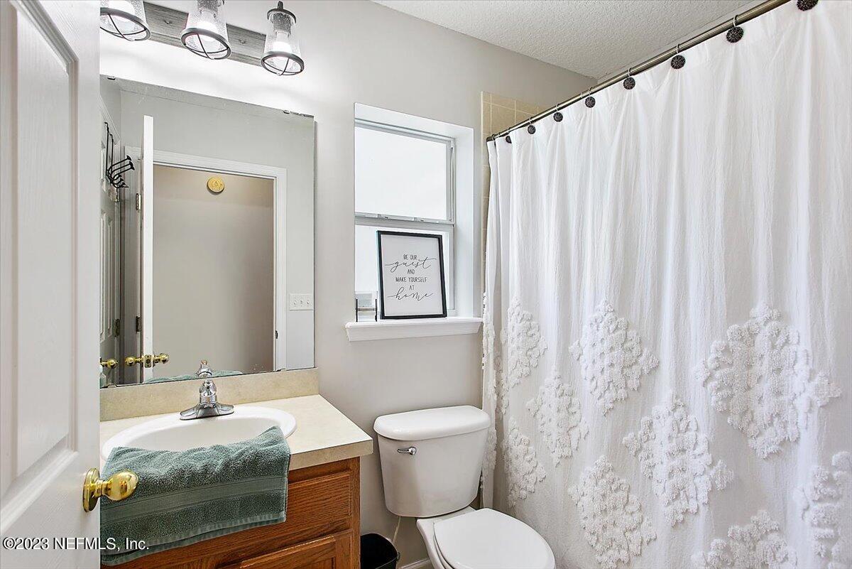 776 Constitution Place Macclenny, FL 32063 - Photo 16 of 30 a bathroom with a granite countertop sink and a mirror