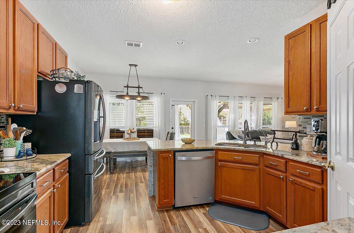 776 Constitution Place Macclenny, FL 32063 - Photo 10 of 30 a kitchen with sink a refrigerator and wooden cabinets