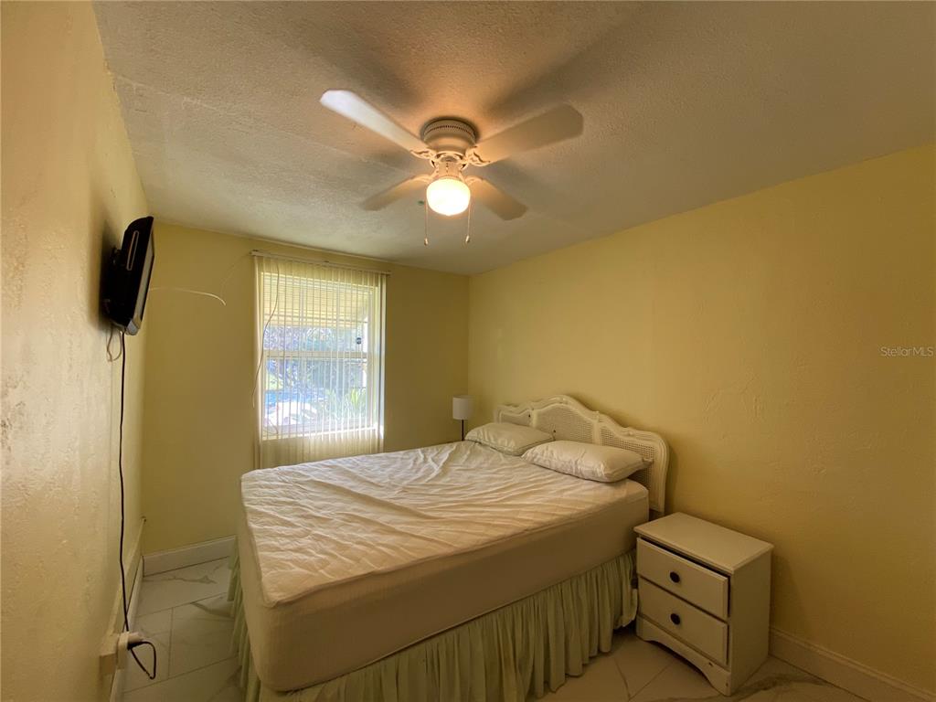 910 Lake Avenue Edgewater, FL 32132 - Photo 14 of 23 a bedroom with a bed and a chandelier