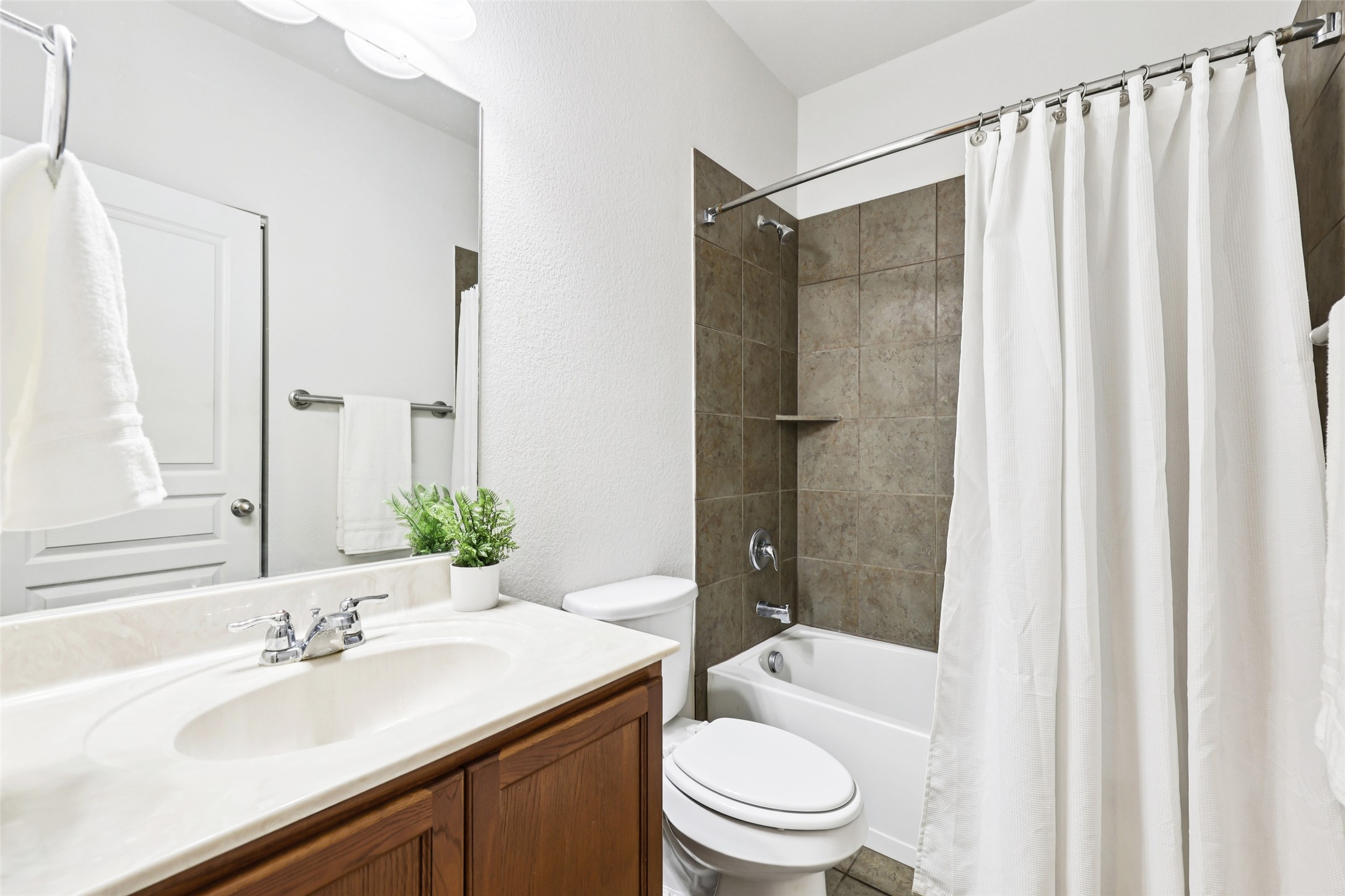 1524 Sanders Kyle, TX 78640 - Photo 25 of 37 Full bathroom featuring vanity, shower / bath combo, and a textured wall