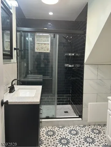 a bathroom with a shower a mirror and a sink