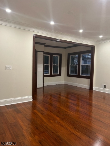 904 Cross Elizabeth, NJ 07208 - Photo 5 of 27 an empty room with wooden floor and windows