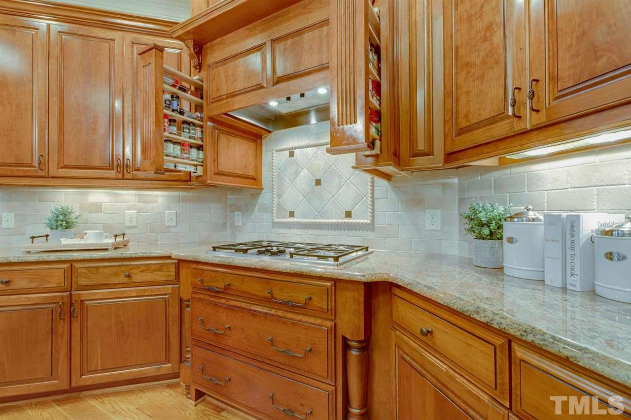 1317 Caistor Lane Raleigh, NC 27614 - Photo 5 of 22 The gas cook top has cabinets above with HIDDEN SPICE RACKS -so convenient! There's a WARMING DRAWER and also some nice pull out basket storage in the island.