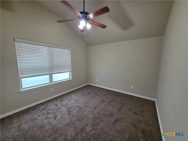 an empty room with a window and a fan