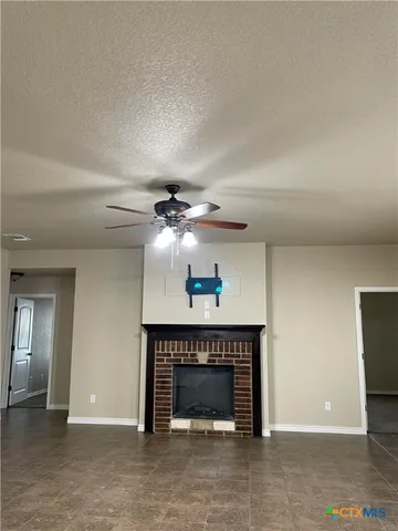 an empty room with fireplace and fan