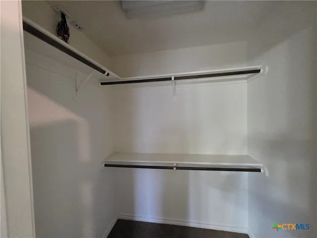 a view of walk in closet with empty racks