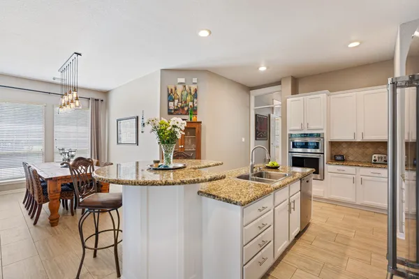 a kitchen with sink refrigerator and cabinets