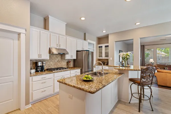 a kitchen with granite countertop kitchen island white cabinets and stainless steel appliances