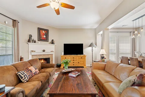 a living room with furniture a flat screen tv and a fireplace