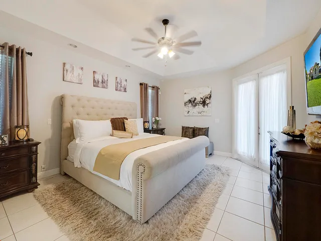 a bedroom with a large bed and a chandelier