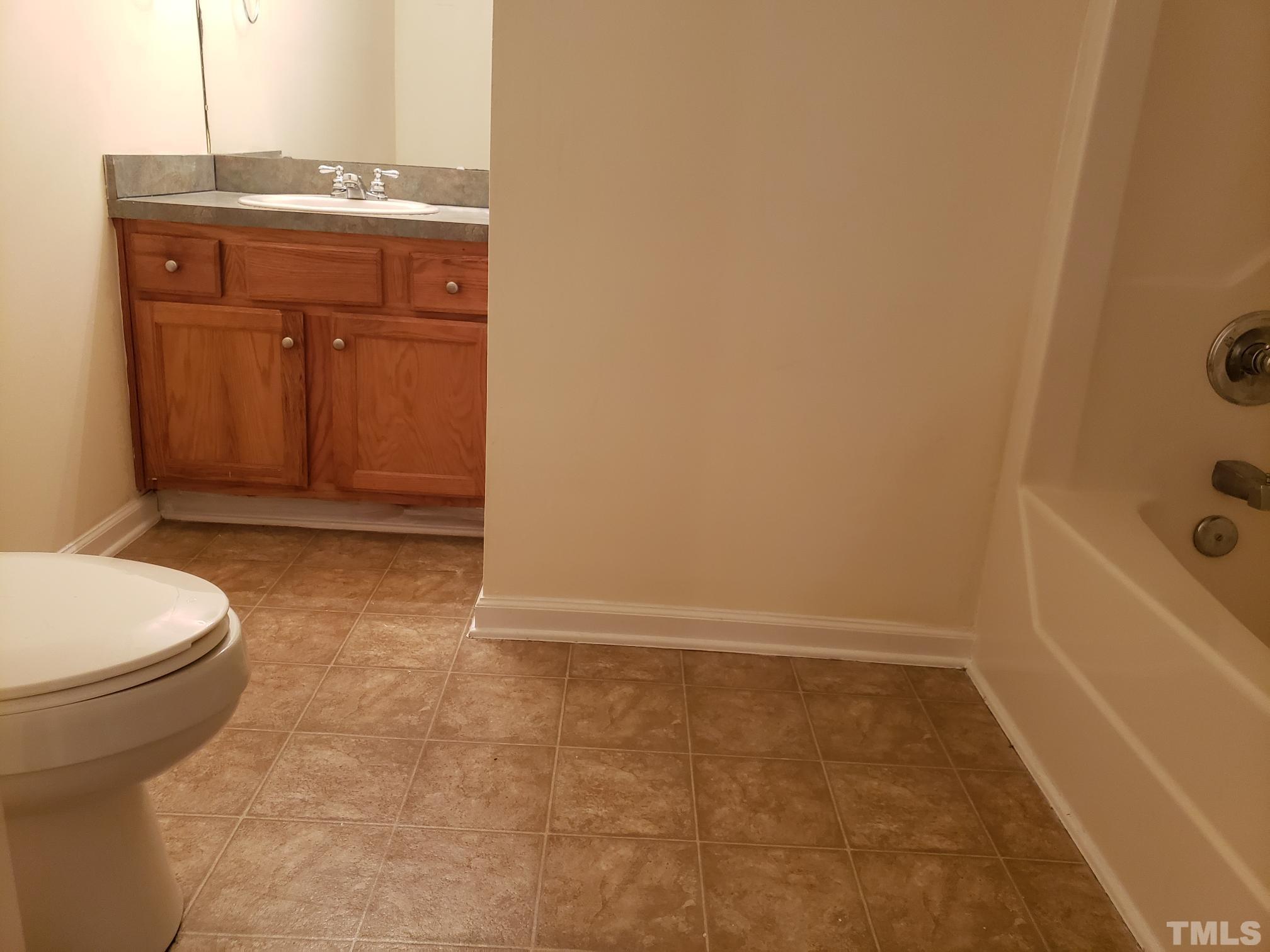 542 Barnes Lake Road, Unit B Middlesex, NC 27557 - Photo 11 of 16 a bathroom with a granite countertop sink a toilet and bathtub