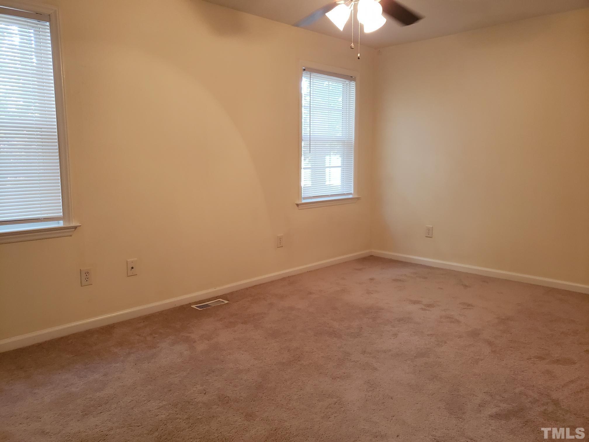 542 Barnes Lake Road, Unit B Middlesex, NC 27557 - Photo 9 of 16 an empty room with a chandelier fan and windows