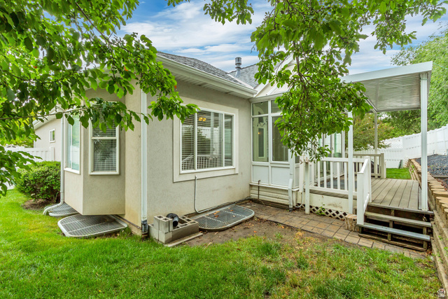 1433 Forge Way Draper, UT 84020 - Photo 27 of 29 Rear exterior featuring a sunroom, an attached deck with a covered patio, and manicured green space