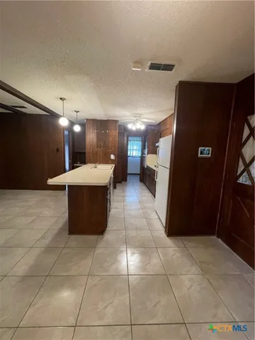 a view of a refrigerator in an empty room