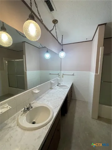 a bathroom with a granite countertop sink a mirror and vanity