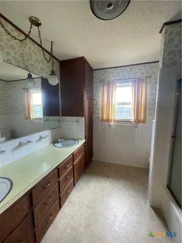 a bathroom with a sink a vanity and a mirror