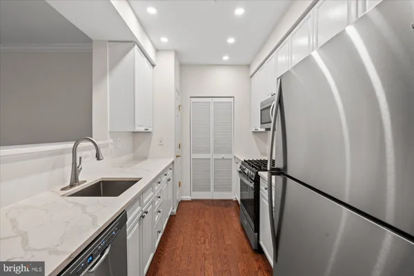 a view of a kitchen with a sink and refrigerator