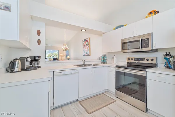 a kitchen with cabinets stainless steel appliances and a counter space