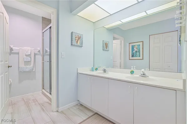 a bathroom with a double vanity sink mirror and shower
