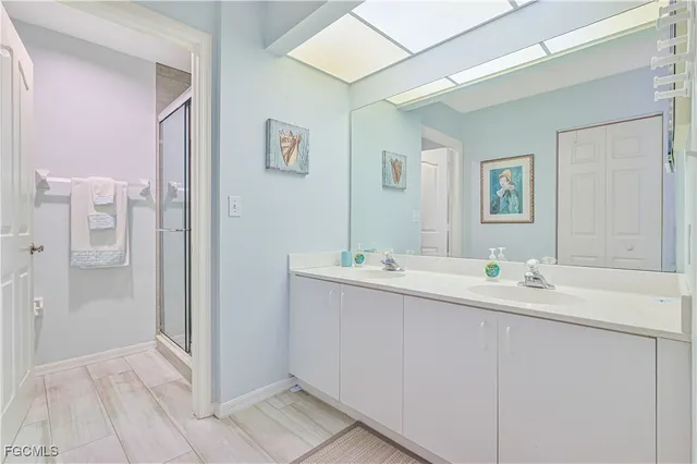 a bathroom with a double vanity sink mirror and shower