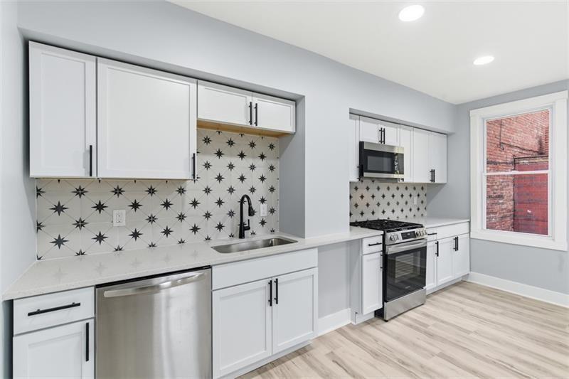 1150 Goettmann Street Pittsburgh, PA 15212 - Photo 2 of 36 a kitchen with granite countertop a sink stove and refrigerator