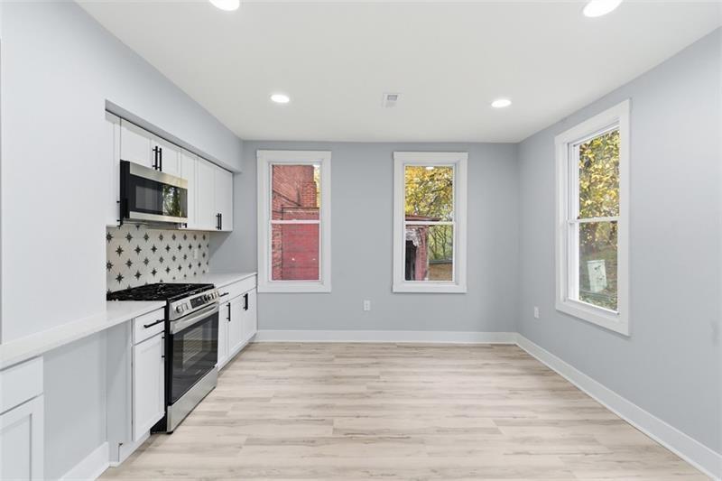 1150 Goettmann Street Pittsburgh, PA 15212 - Photo 5 of 36 a kitchen with stainless steel appliances granite countertop a stove a sink and a refrigerator