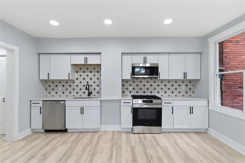 1150 Goettmann Street Pittsburgh, PA 15212 - Photo 6 of 36 a kitchen with white cabinets and stainless steel appliances