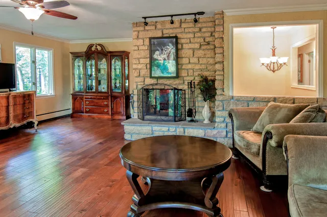 a living room with furniture a fireplace and a chandelier