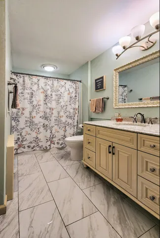 a spacious bathroom with a granite countertop sink a mirror and a bathtub