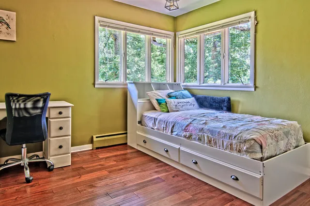 a bedroom with a bed and wooden floor