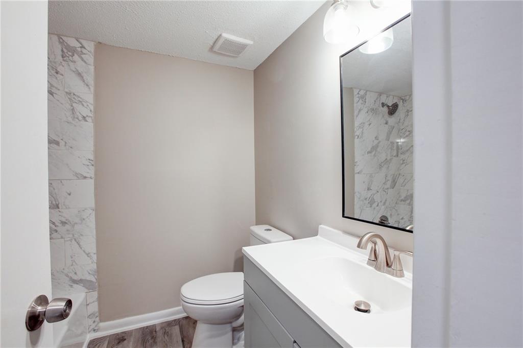 7325 Cardigan Circle Atlanta, GA 30328 - Photo 21 of 25 a bathroom with a sink and mirror with toilet