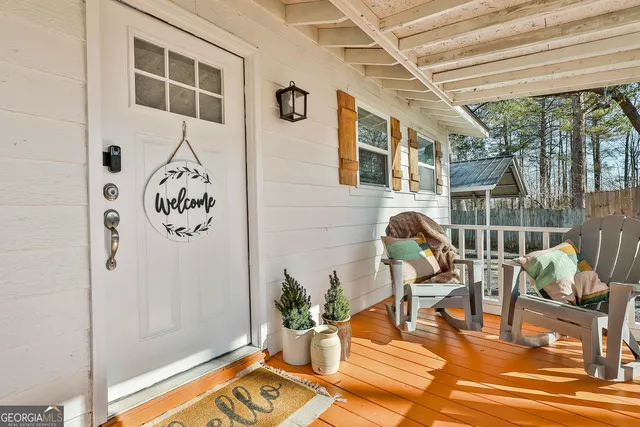 a living room with patio furniture and a potted plant