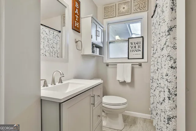 a bathroom with a toilet sink and mirror