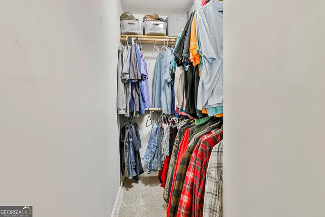a view of walk in closet with clothes