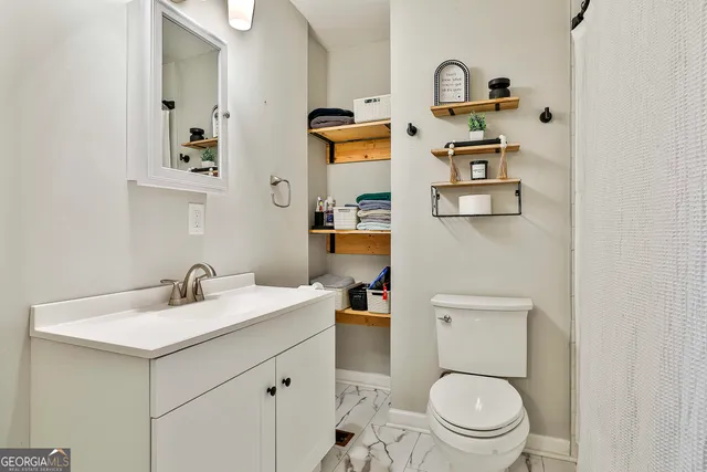 a bathroom with a sink a toilet and a mirror