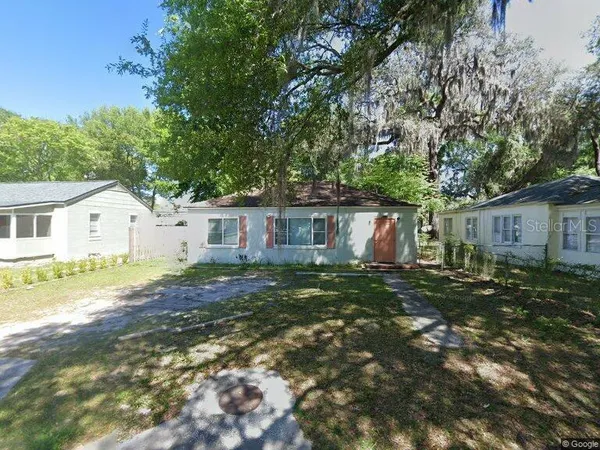a view of a yard with a house and a tree