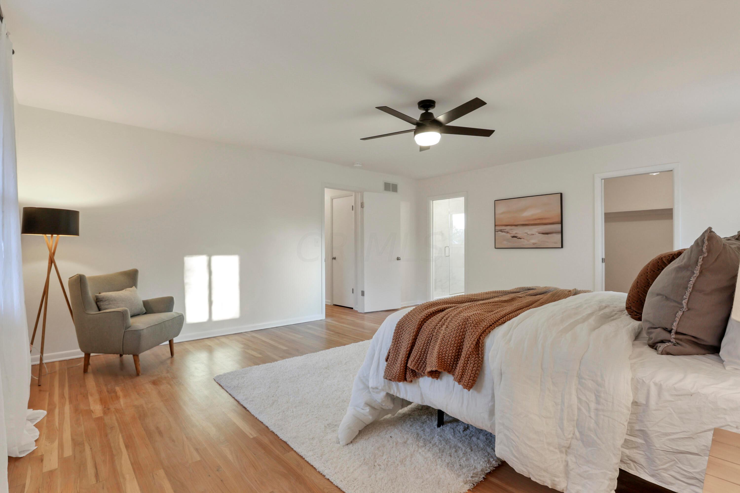 2275 Haverford Road Columbus, OH 43220 - Photo 25 of 57 The spacious Primary Suite offers refinished hardwood floors, ceiling fan, walk-in closet and en suite bathroom.