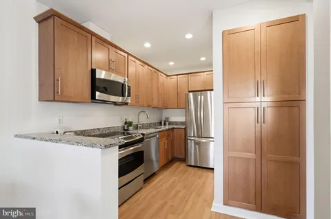 a kitchen with stainless steel appliances granite countertop a refrigerator stove and microwave
