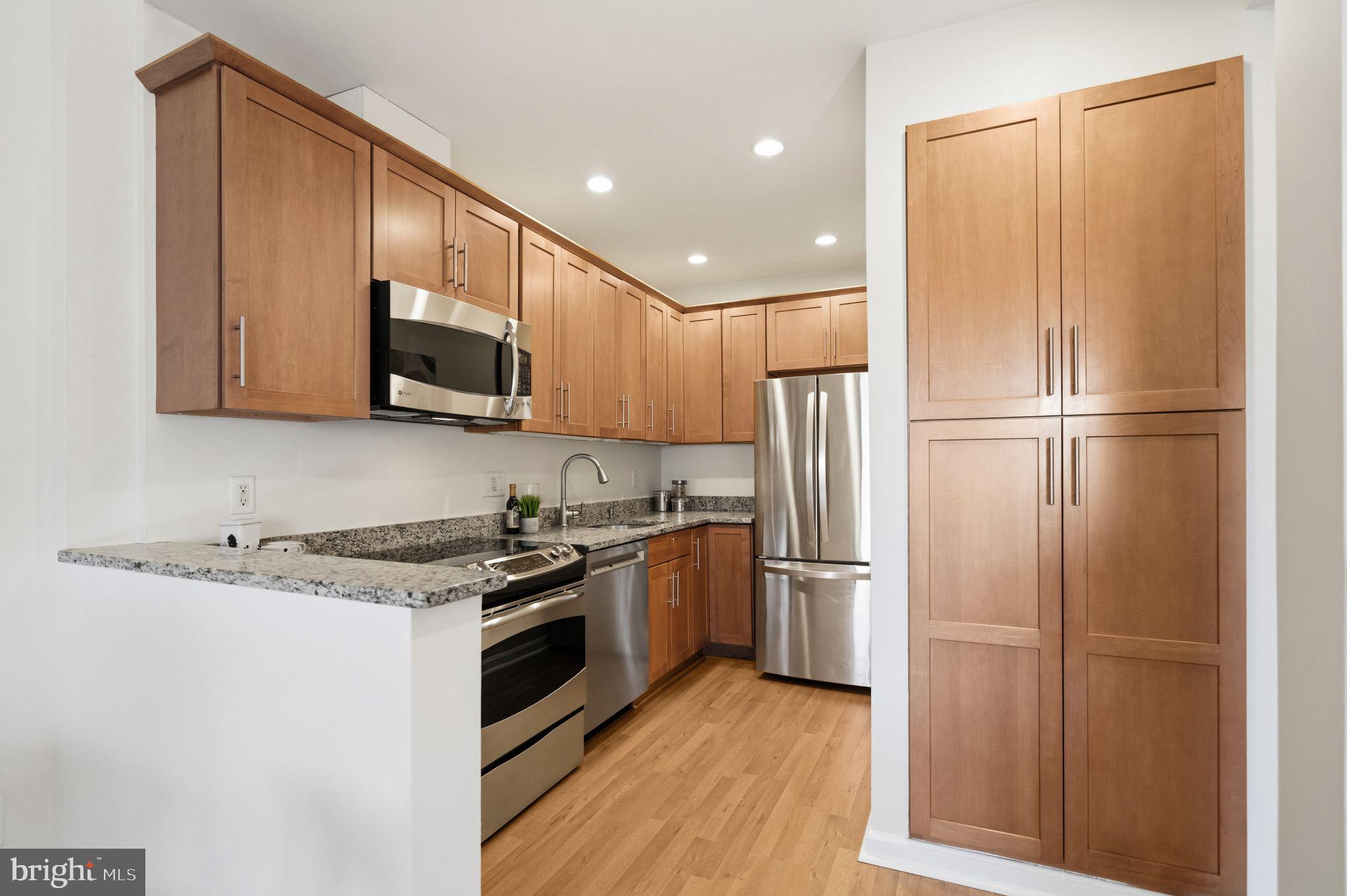 3225 Grace Street Northwest, Unit 226 Washington, DC 20007 - Photo 11 of 45 a kitchen with stainless steel appliances granite countertop a refrigerator stove and microwave